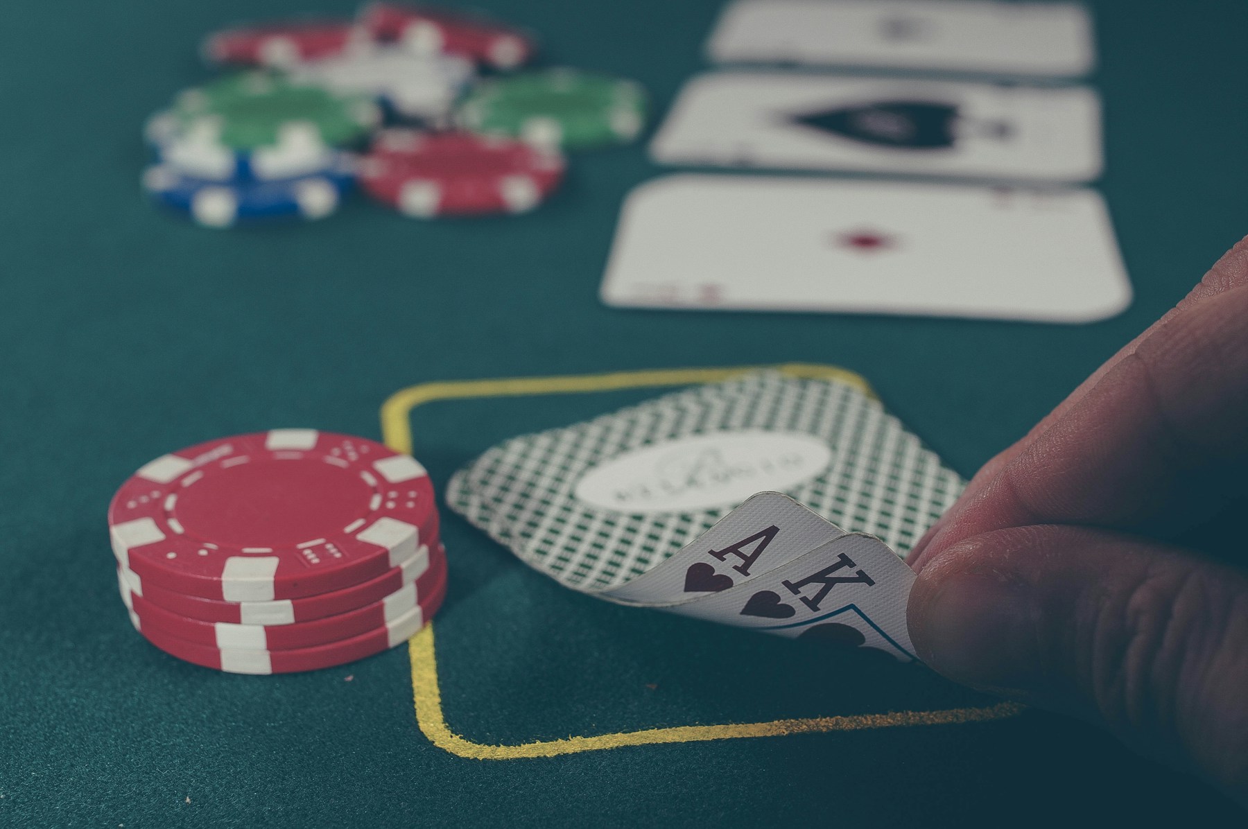 Pokerkarten und Chips auf einem grünen Spieltisch
