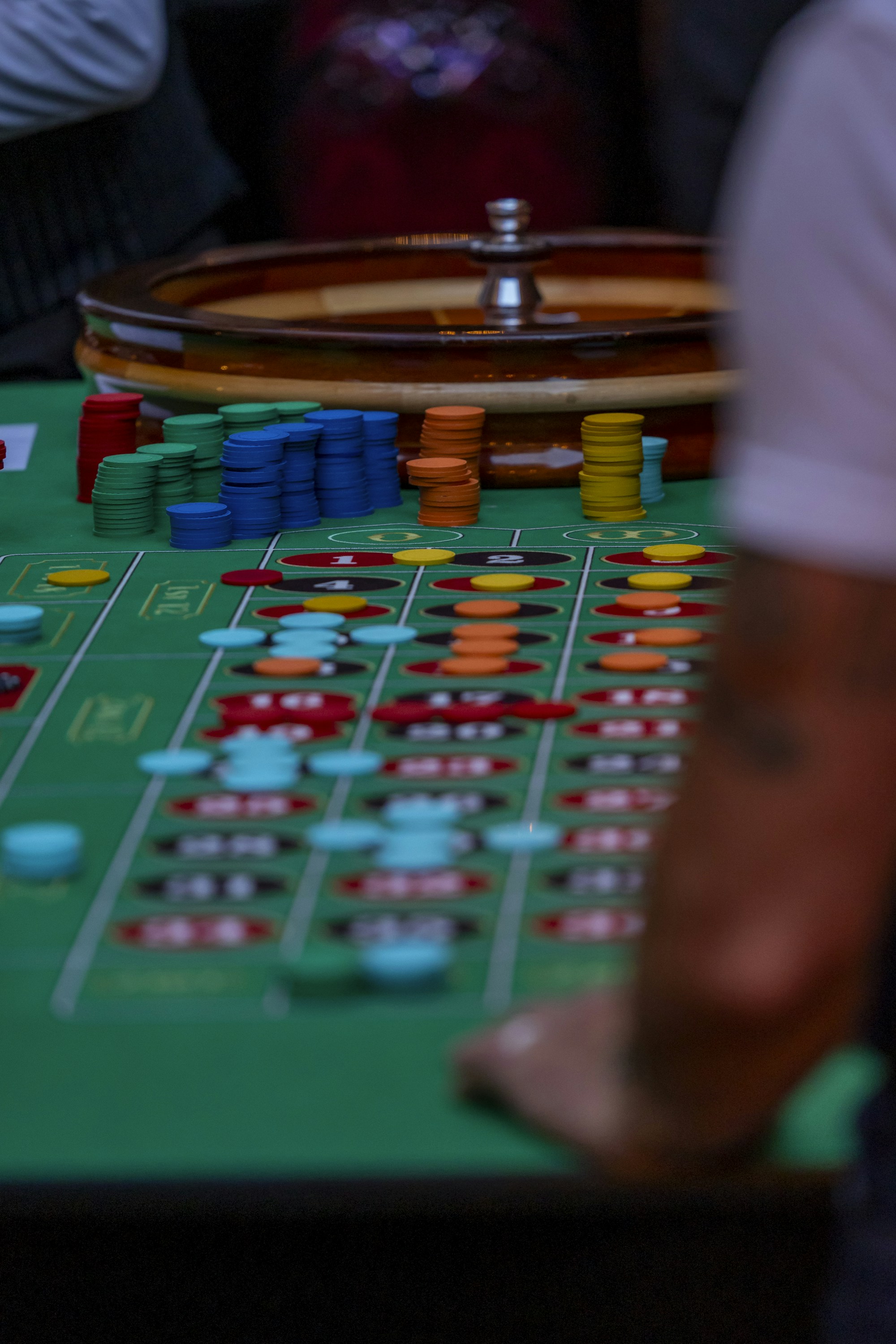Roulette-Tisch mit Chips in einer dunkel leuchtenden Casino-Atmosphäre